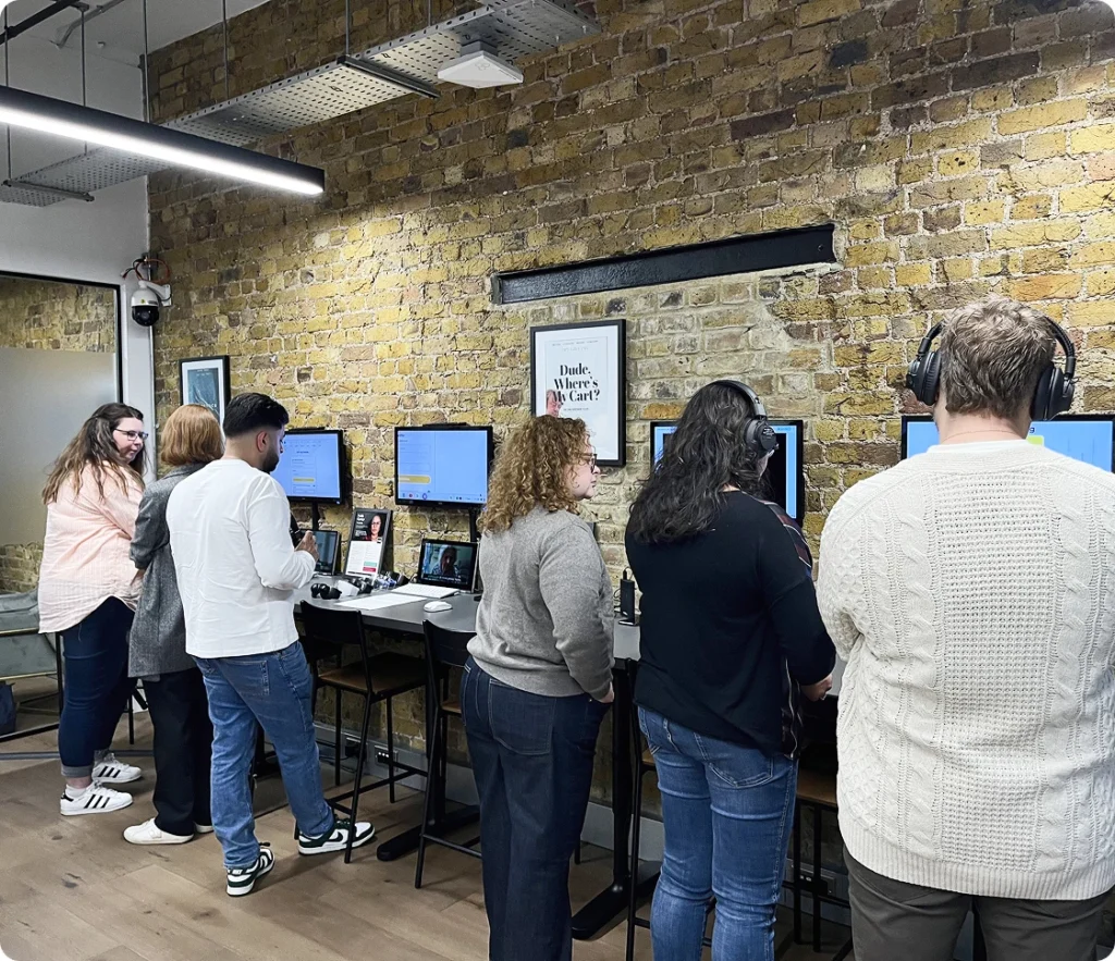 Six people interacting in front of empathy workstations
