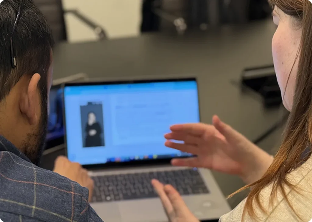 Man and woman using sign language while watching a sign language video on a laptop