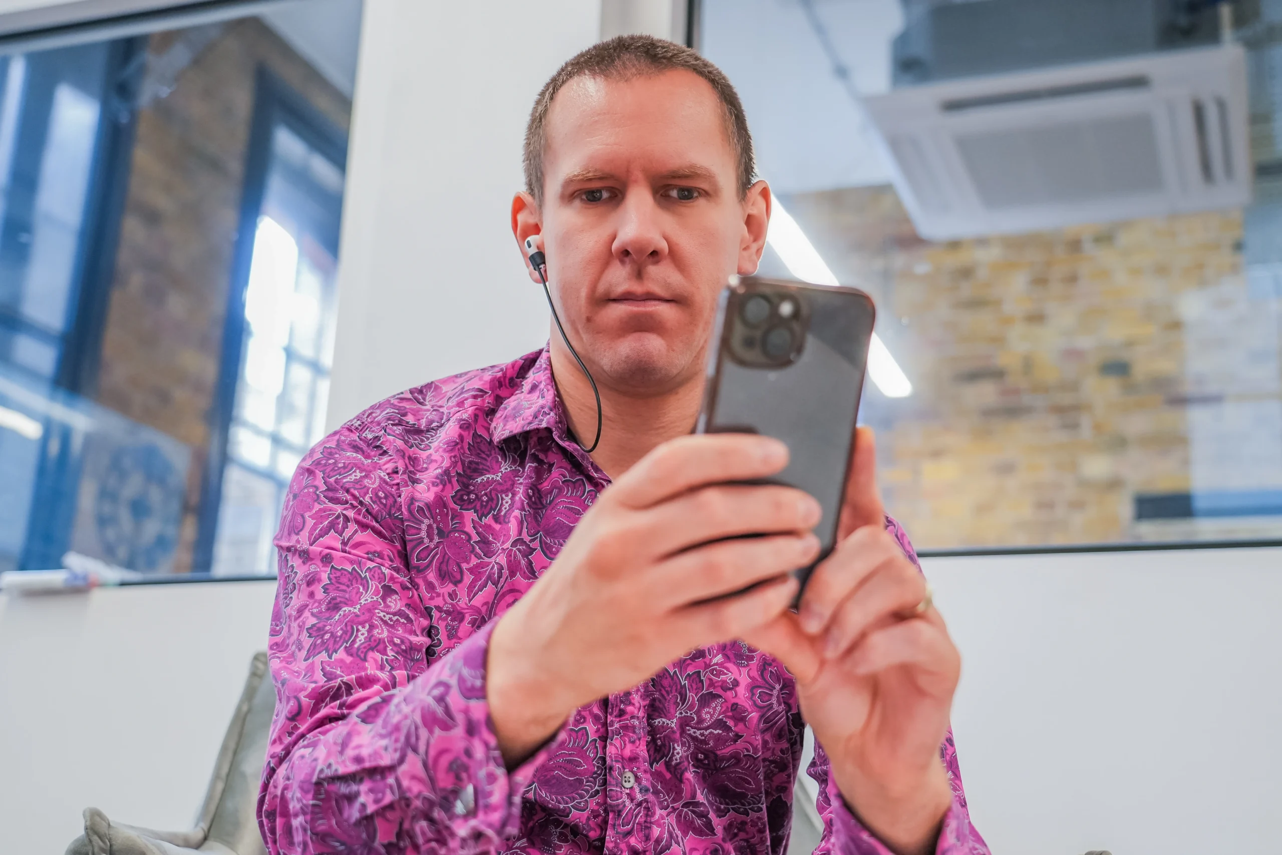 Blind accessibility tester using a smartphone screen reader with earphones to perform a manual audit.