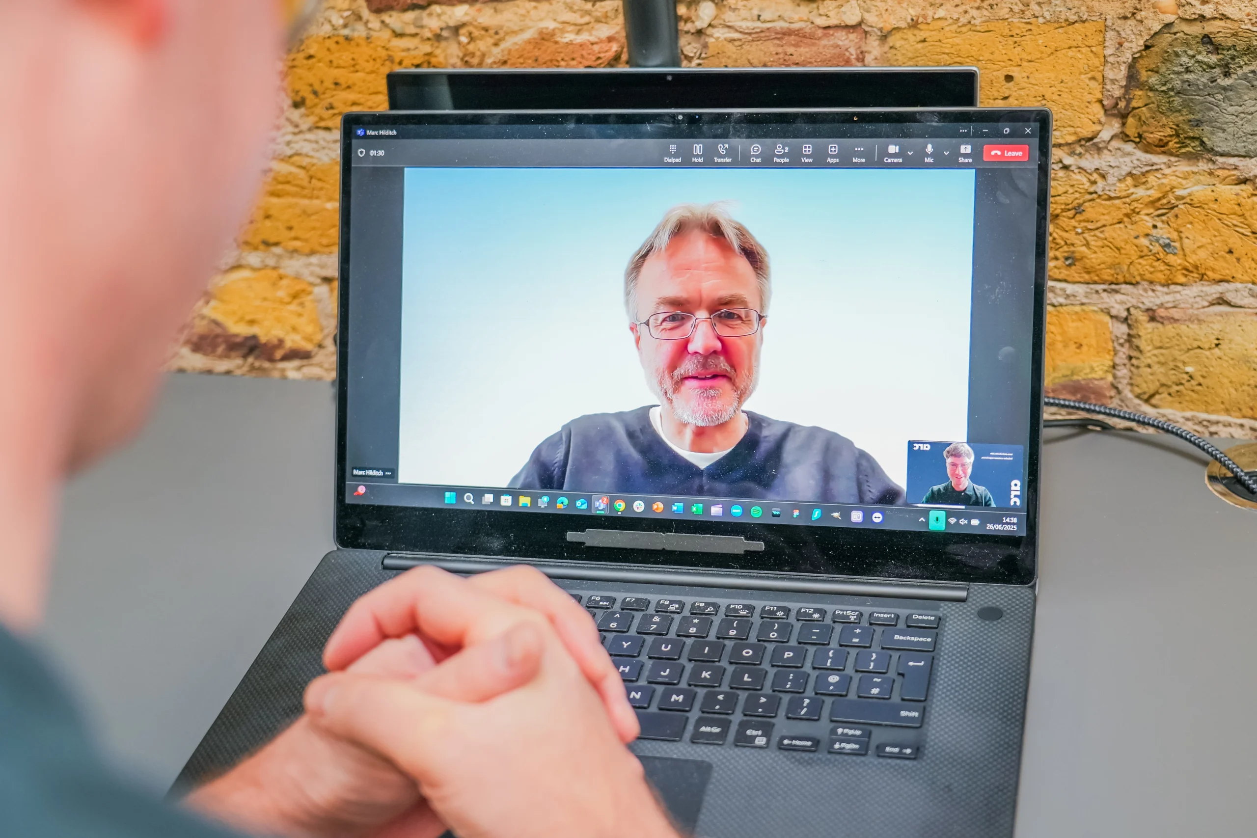 Person on a video call with an accessibility consultant, shown on a laptop screen during a remote pair programming session.