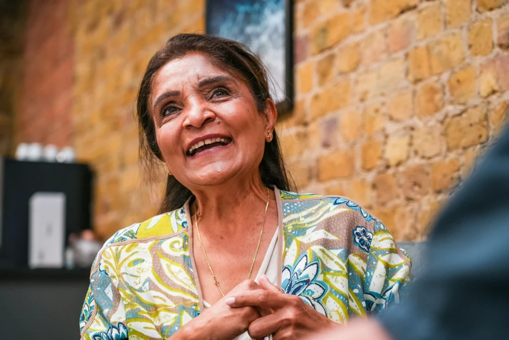 A smiling older woman in conversation, symbolising a friendly and approachable approach to compliance and accessibility.