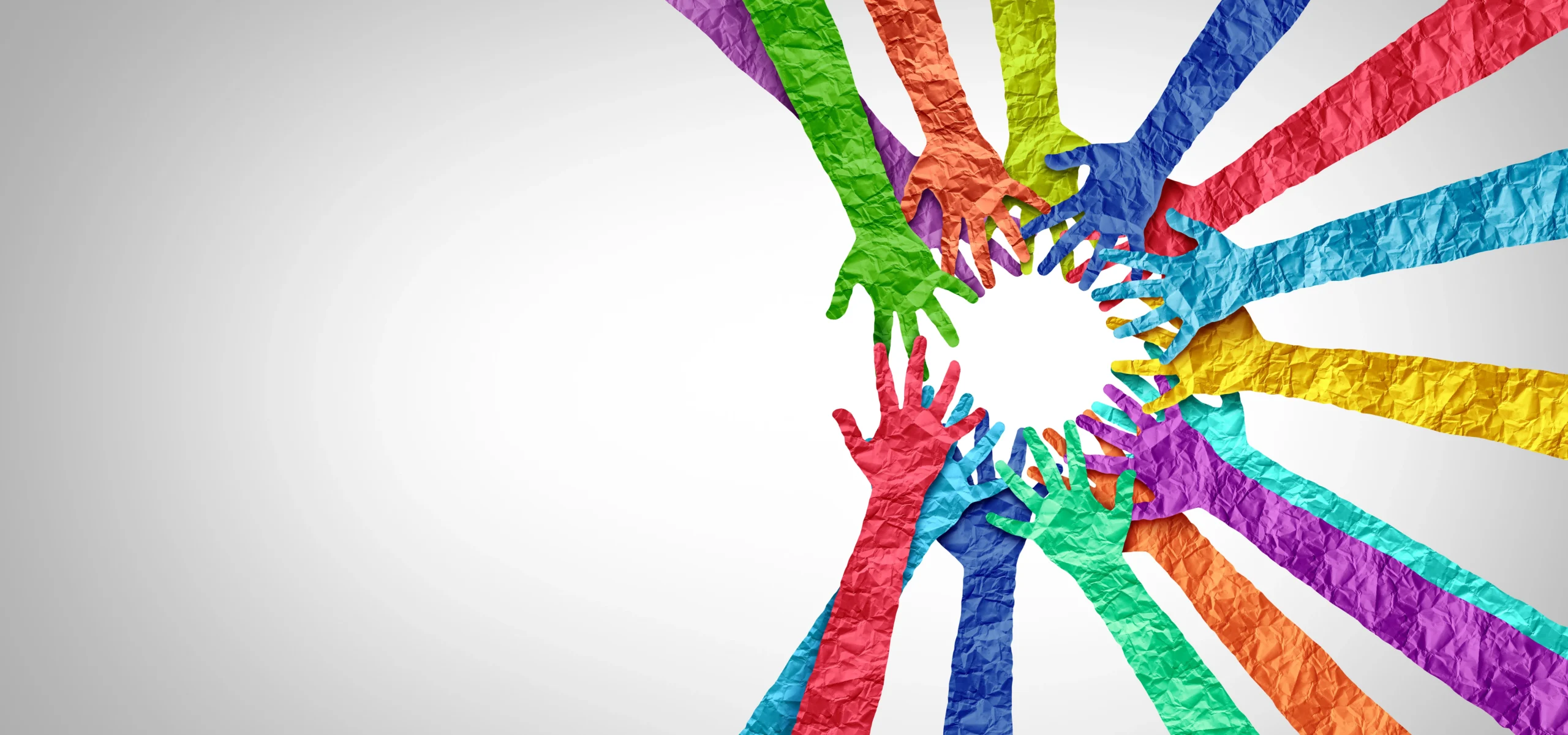 Multiple colourful hands made of crumpled paper reaching toward the centre, symbolising unity and collaboration in a circular formation.
